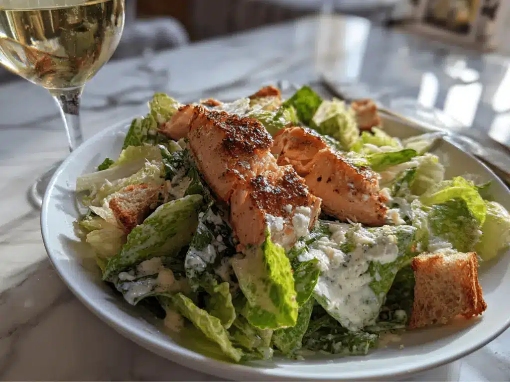 plated Salmon Caesar Salad served with a light drink