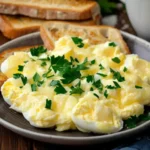 Garlic butter eggs served with toast and fresh parsley on a plate in morning light